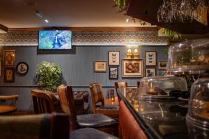 a restaurant with a bar with chairs and a table at The Loans Inn in Troon