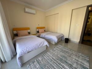 une chambre avec deux lits et un tapis dans l'établissement Cozy cheap apartment, à Burg el-Ḥudûd