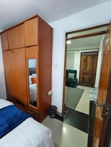 a bedroom with a bed and a wooden cabinet at Tranquil 2 homes in Nanyuki +2 photos