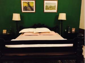 a bedroom with a bed with a green wall at The Sarovar Palace in Prayagraj