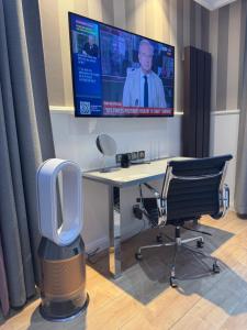 an office with a desk with a tv and a chair at Résidence des Fleurs in Hombourg-Haut +35 photos