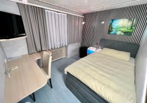 Un dormitorio pequeño con una cama y un escritorio. en Seiler's Hotel, en Liestal