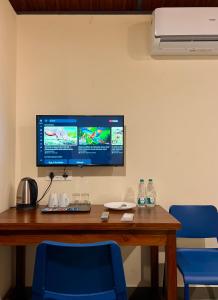 a desk with a computer monitor and two blue chairs at Hill View Heights Wayanad in Meppādi