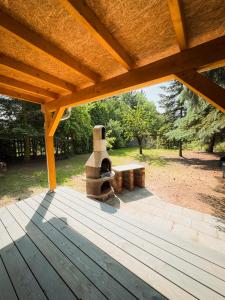 a patio with a stone oven under a wooden roof at Ferienwohnung Burgkemnitzer Weg in Gröbern +21 photos