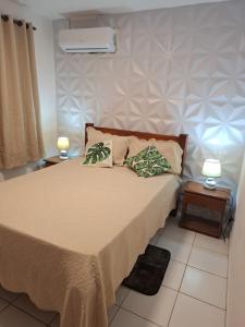 En eller flere senge i et værelse på Condomio Coqueiros Residence