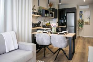 a kitchen and living room with a table and chairs at Lobos Dream Flat by Escape to Madeira in Câmara de Lobos +18 photos