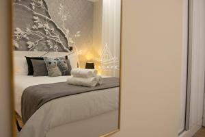 a mirror reflection of a bedroom with a bed at Lobos Dream Flat by Escape to Madeira in Câmara de Lobos