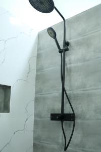 a shower with a microphone on a wall at Staysia Guest in Kandy