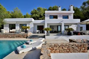 a villa with a swimming pool and a house at Tranquil 4BR Villa in the Heart of Ibiza City,1046 in Sant Josep de Sa Talaia