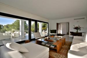a living room with white furniture and large windows at Tranquil 4BR Villa in the Heart of Ibiza City,1046 in Sant Josep de Sa Talaia
