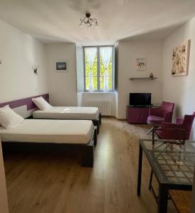 a room with two beds and a window at Le Studio des Demoiselles in Rochefort