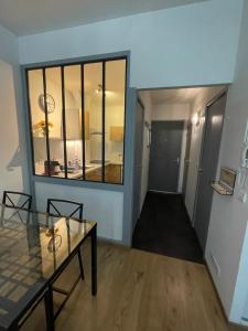 a hallway with a glass table and a window at Le Studio des Demoiselles in Rochefort