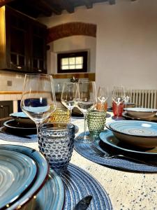 a table with plates and wine glasses on it at Casa Leonardo in Poggio Alla Croce