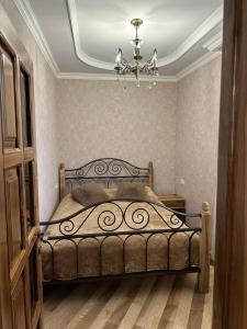 a bedroom with a bed and a chandelier at Remember Me B&B in Dilijan
