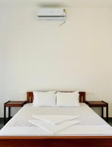 a white bed with white sheets and pillows at Hill View Heights Wayanad in Meppādi