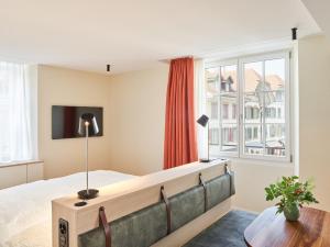 a bedroom with a large bed and a window at KORNHAUS Boutique Hotel in Murten