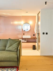 a living room with a couch and a bathroom at KORNHAUS Boutique Hotel in Murten