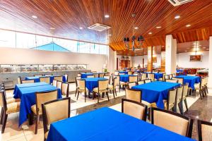 a dining room with blue tables and chairs at Swamy Hotel in Cruzeiro do Sul