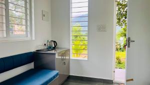 a kitchen with a blue bench in front of a window at Hill View Heights Wayanad in Meppādi