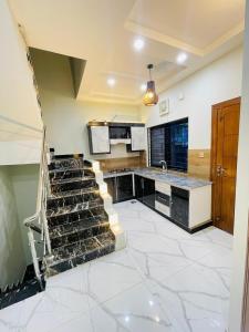 a large kitchen with a staircase in a room at Cozy & comfy House in Rawalpindi