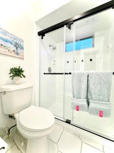 a white bathroom with a shower and a toilet at Poolside Suite APT 15 min from ThemeParks & MCO in Kissimmee