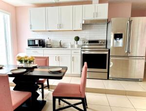 a kitchen with a table and a stainless steel refrigerator at Poolside Suite APT 15 min from ThemeParks & MCO in Kissimmee