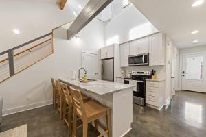 a kitchen with white cabinets and a kitchen island with chairs at Modern King Bed Patio Central Lafayette in Lafayette