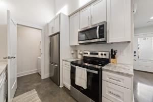 a kitchen with white cabinets and a black stove top oven at Modern King Bed Patio Central Lafayette in Lafayette
