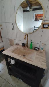 a bathroom with a wooden sink with a mirror at Entre Cerros Tiny House Única in Moquehue +14 photos