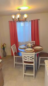 a dining room table and chairs with red curtains at 4-plex Apartment in Burien - Unit 1 - 7 min from Sea Tac Airport - 15 min from Downtown Seattle in Burien +6 photos