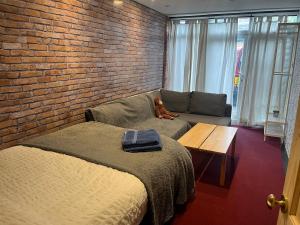 セールにあるThe Studio at The Shackのソファ付きのベッドルーム1室、レンガの壁