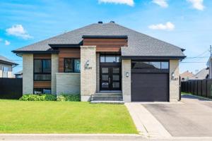 a house with a garage in a yard at Appartement BBNK in Mirabel