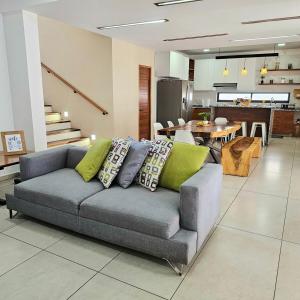 a living room with a gray couch with green pillows at Burgos Cuernavaca Pool Terrace & Garden in Temixco