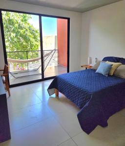 a bedroom with a blue bed and a balcony at Burgos Cuernavaca Pool Terrace & Garden in Temixco +37 photos