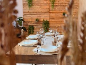 Una mesa de madera con platos y copas de vino encima. en City Center & Free Parking - Rest & Nest Boho Deluxe Apartment, en Debrecen
