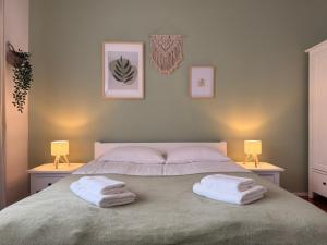 Un dormitorio con una cama con dos toallas encima. en City Center & Free Parking - Rest & Nest Boho Deluxe Apartment, en Debrecen