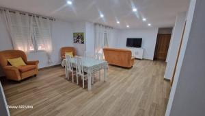 a living room with a table and chairs and a television at Alojamiento Paco Cabrera 3C Reformado in Almuñécar