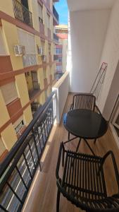 a balcony with a table and chairs on a building at Alojamiento Paco Cabrera 3C Reformado in Almuñécar