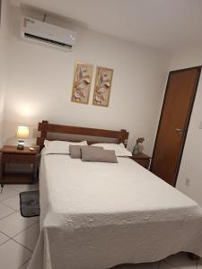 En eller flere senge i et værelse på Condomio Coqueiros Residence