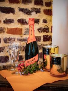 a bottle of wine and two glasses on a table at Au Vent des Blés in Incourt