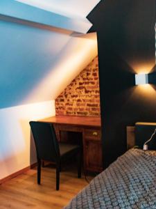 a bedroom with a desk and a bed in a room at Au Vent des Blés in Incourt +4 photos