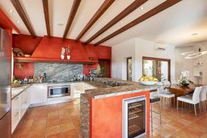 a large kitchen with red walls and a large center island at Exclusive 4 Bedroom Villa in Mahon 1281 in Sant Carles de Peralta