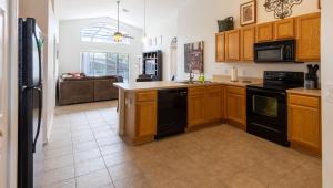 a kitchen with wooden cabinets and black appliances at AV340RD 4 Bedroom Charming Villa in Aviana home in Loughman