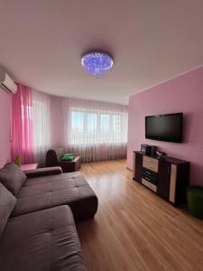 a living room with a couch and a flat screen tv at Сдам 1к квартиру в Новом Доме у моря! Переулок Хантадзе in Chornomorsk