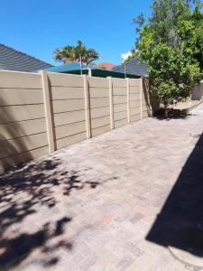 a wooden fence in front of a house at Boston Airport Lodge in Bellville +3 photos