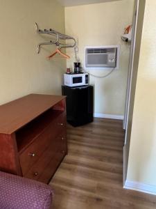 a small room with a kitchen with a microwave at Choice Inn in Clovis