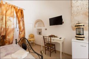 a bedroom with a bed and a desk with a computer at Trullo Abbracciavento in Martina Franca