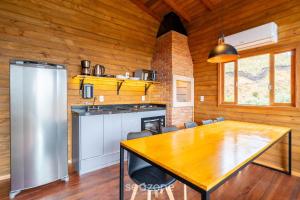 a dining room with a table and a kitchen at Apto c/ lareira, jacuzzi e vista incrível - VST027 in São Paulo dos Pinhais +21 photos