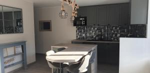 a kitchen with a table with chairs and a counter at Port de La Houle - Beau 2 pièces classé 3 étoiles avec stationnement in Cancale