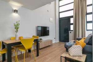 a living room with a table and yellow chairs at NUEVO Amplio dúplex en la zona del Palacio de Vista Alegre in Madrid